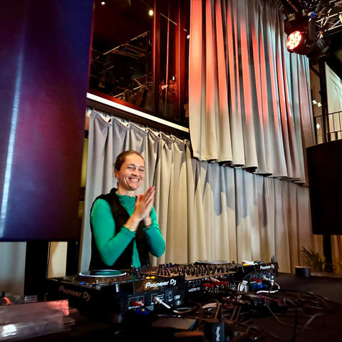 The DJ smiling behind the decks