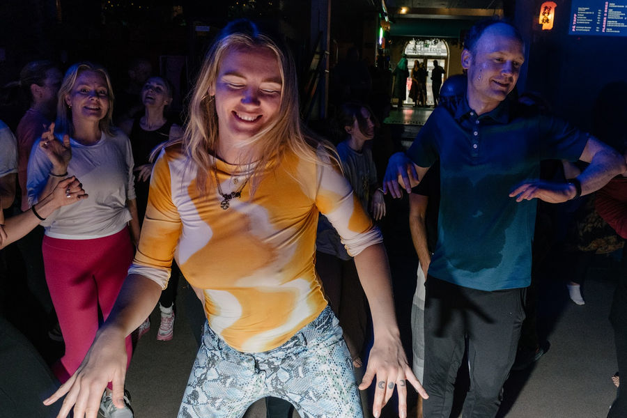 A dancer in yellow grinning at the camera