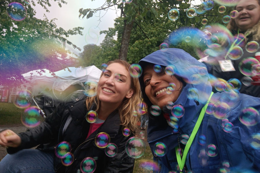 Two friends laughing among soap bubbles