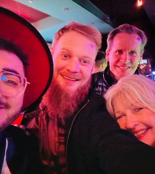 Barbara and Tom selfie with two people at a bar