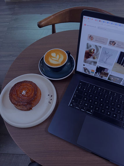 coffee, laptop and cinnamon swirl on the desk