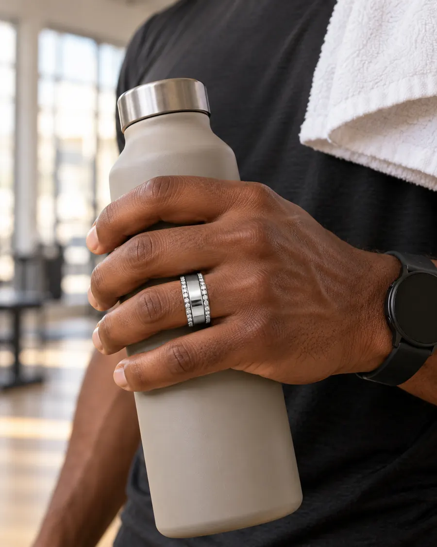 Man wearing HALO Round in 14k white gold over a silver Oura Ring, holding a water bottle after a workout