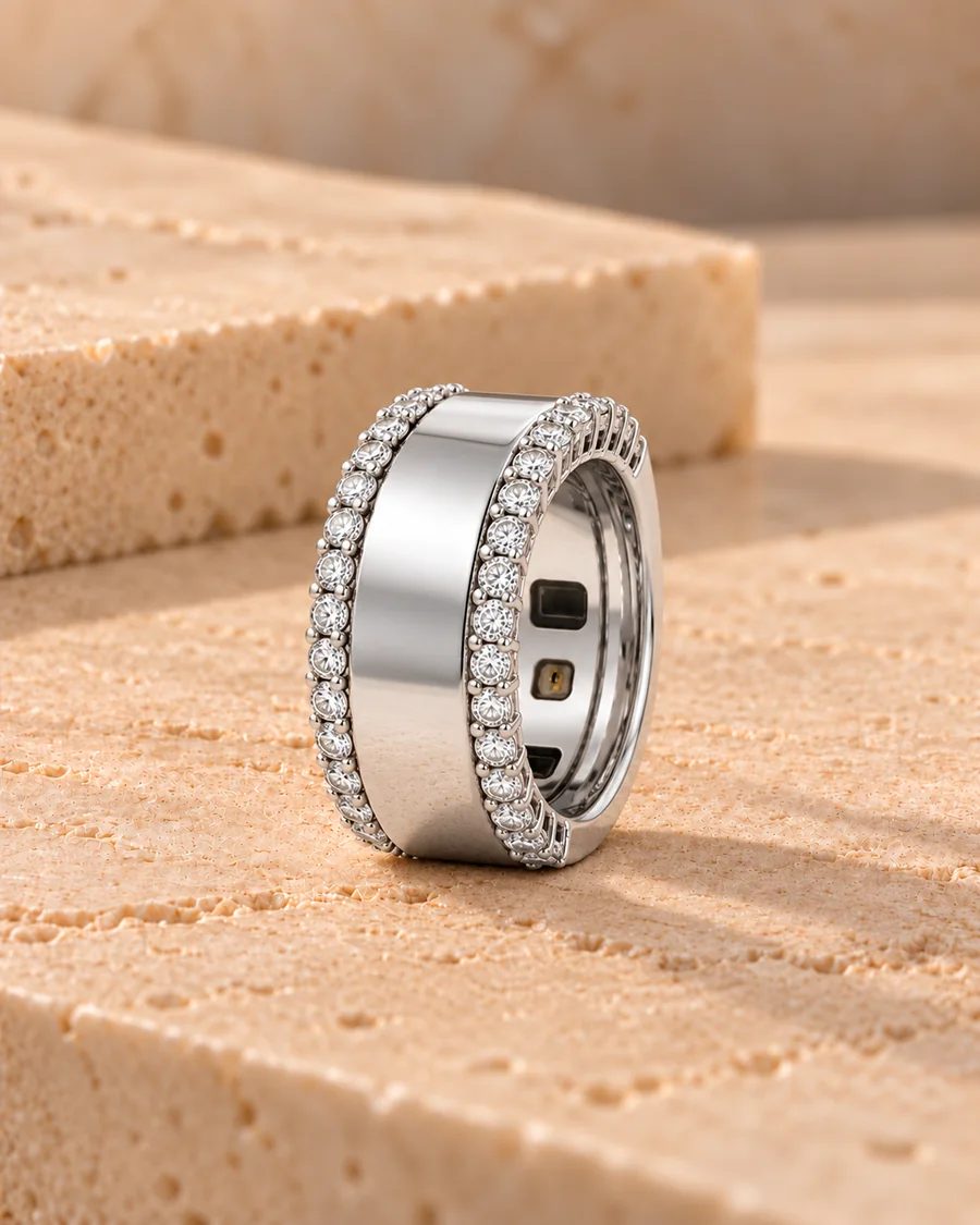 HALO Round in 14k white gold with two rows of round brilliant diamonds, worn over a silver Oura Ring, standing on sandstone