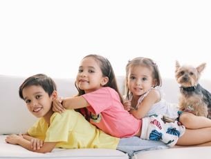 3 children and a dog lying on a couch
