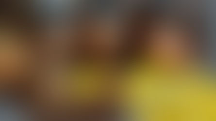 Jars of brown liquid with lids, a glass mug, a copper kettle, yellow patterned cloth, and brown twine on a speckled countertop.