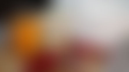 Jar of peaches, ice cream tub, strawberries, and wrapped treats on a woven mat. A white appliance in the background on a granite surface.