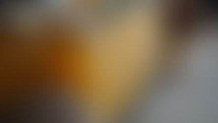 Jars filled with amber liquid on a kitchen counter, with pinecones and wood board in the background. The setting is warm and cozy.
