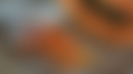 Sliced papaya in a jar spills onto a brown fabric. A halved papaya with black seeds is nearby, set on a woven textured background.