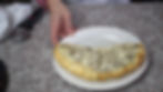 calzone on a plate with a woman's hand on a granite counter with a pizza cutter in the background