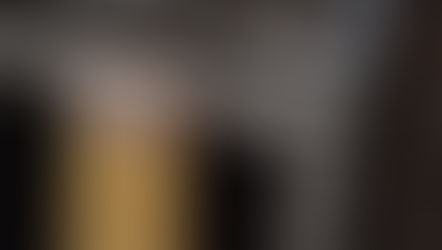 Yellow towel with floral-patterned top hanging on a stainless steel oven handle. Neutral kitchen setting, no visible text.