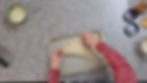 a woman folding the edge of a calzone on a baking sheet