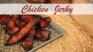 Chicken jerky pieces on a gray tray, placed on a woven mat. Text "Chicken Jerky" overlays the image in bold script.