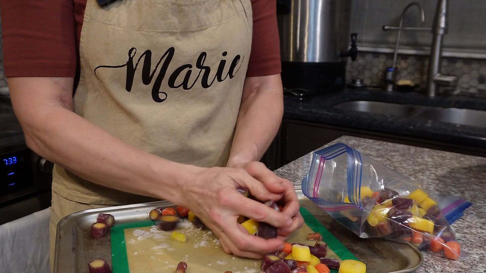 Person wearing an apron labeled "Marie" rolls colorful dough on a green mat in a kitchen. Nearby, a bag of similar dough pieces.