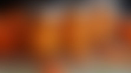 Jars of peeled mandarins on a woven mat with whole mandarins in the background. Orange hues dominate the cozy kitchen setting.