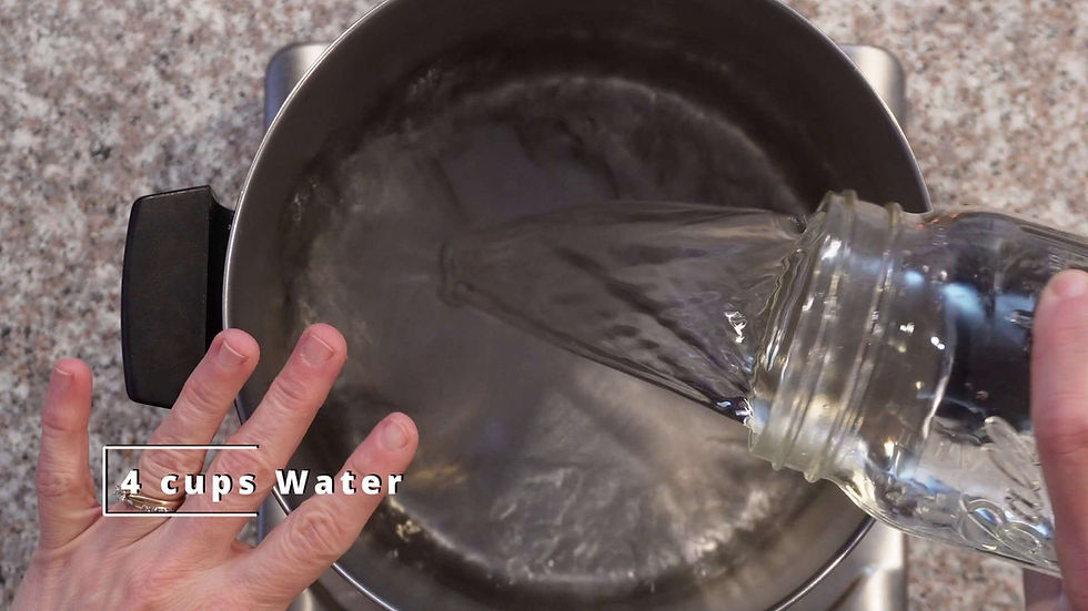 Pouring water from a jar into a pot on a stove, with hands visible. Text reads "4 cups Water." Granite countertop background.