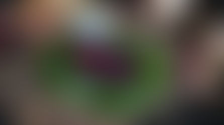 Jar of pickled beets and sliced beets on a plate, garnished with parsley. Autumn leaves and a straw mat enhance the rustic setting.