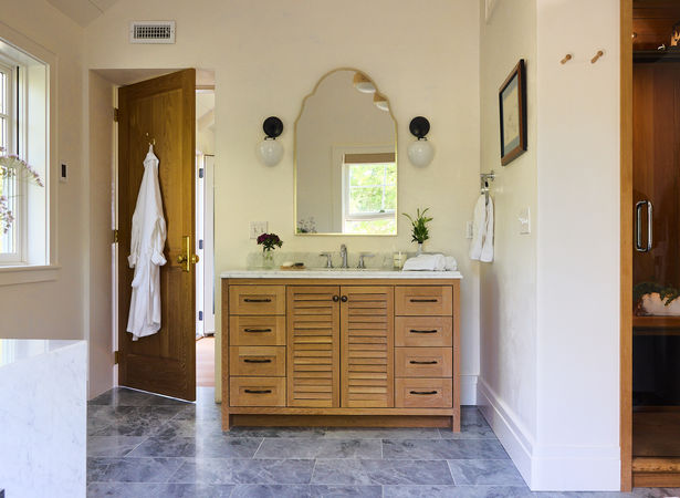 Bathroom vanity with arched mirror and wood cabinetry in Middletown ADU.