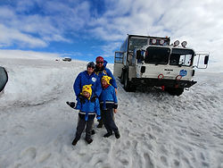 Terra with her husband and 2 sons standing on a glacier in Iceland.