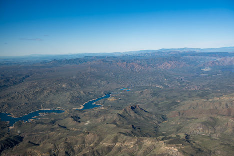 Aerial views of desert landscapes, mountain ridges, waterways, and a small aircraft, including runway and in-flight images.