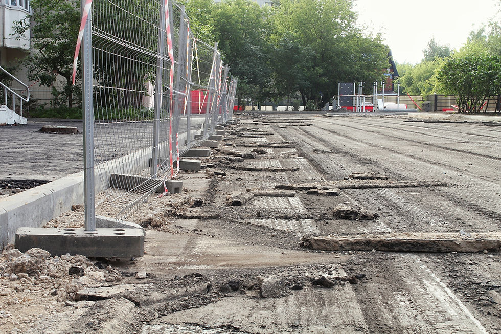 Construction of a road or parking lot in a residential area featuring a temporary metal wi