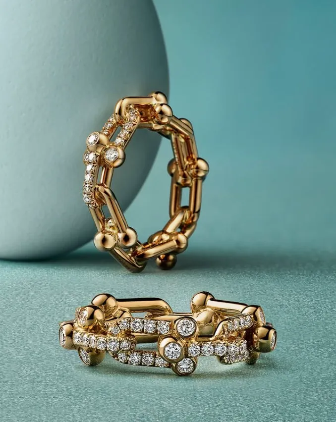 dos anillos dorados y una esfera azul sobre fondo azul