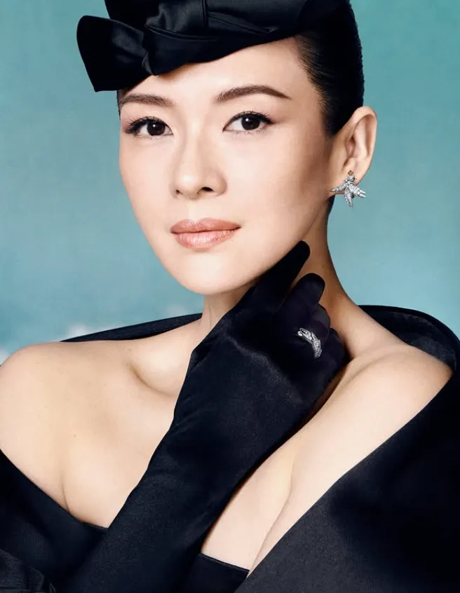 mujer vestida de oscuro con guantes y gorro, lleva un anillo y unos pendientes plateados 