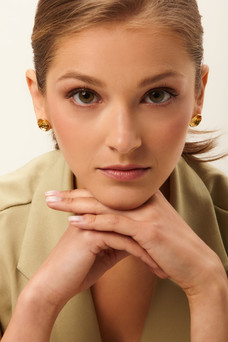 Chica rubia con el pelo recogido y pendientes dorados