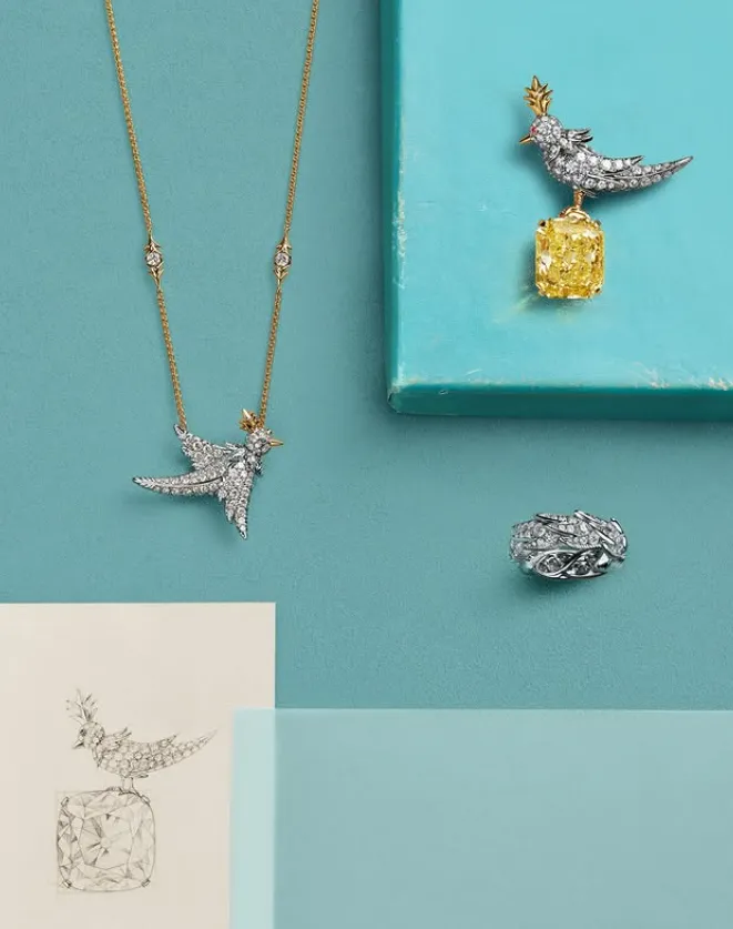 collar, broche y anillo plateados sobre fondo azul