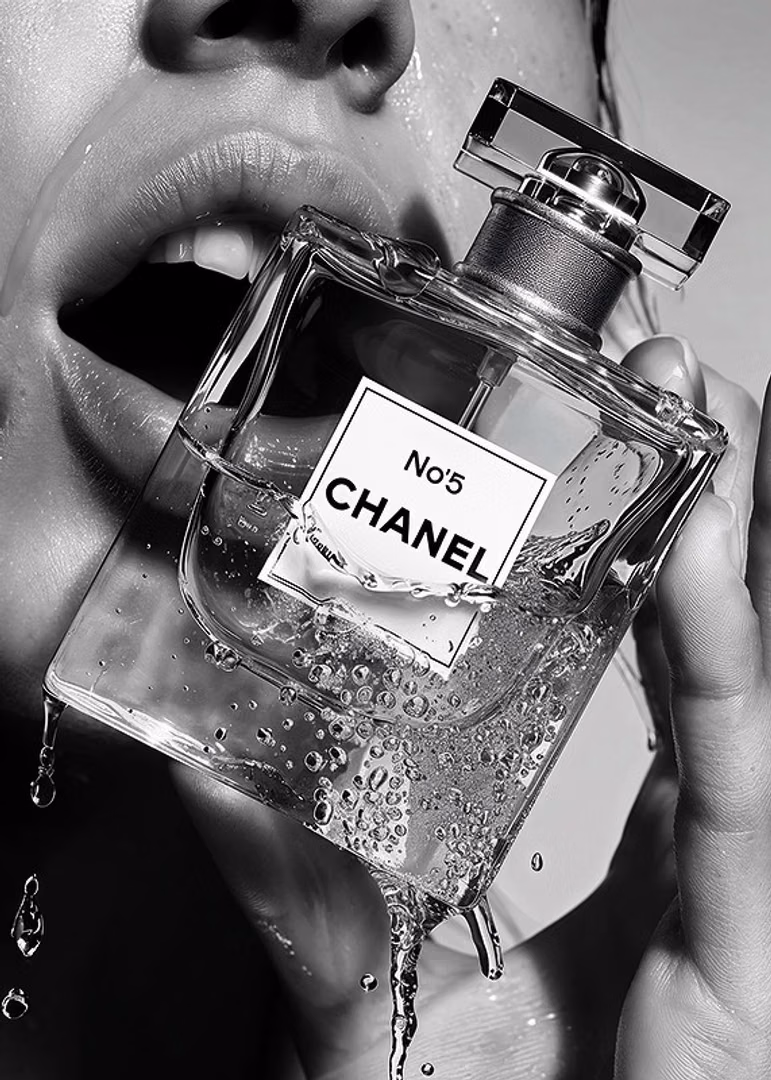 mujer sujetando cerca de sus labios un bote de perfume