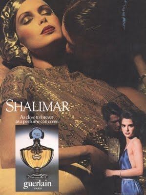 chica tumbada con un vestido dorado junto a un hombre que le besa el cuello