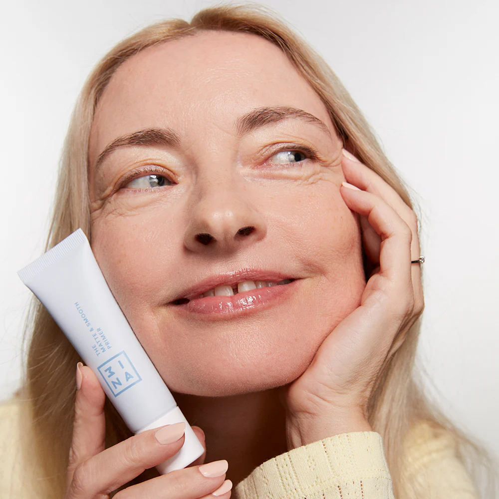 chica rubia sujetando un producto y mirando hacia la derecha