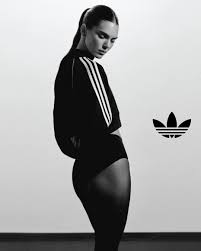 Chica de espaldas con chaqueta y pantalones cortos negros, llevando el pelo recogido en una coleta