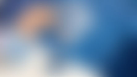 Beine einer Frau, die in einem Pool planschen. Daneben liegen blaue Sandalen.