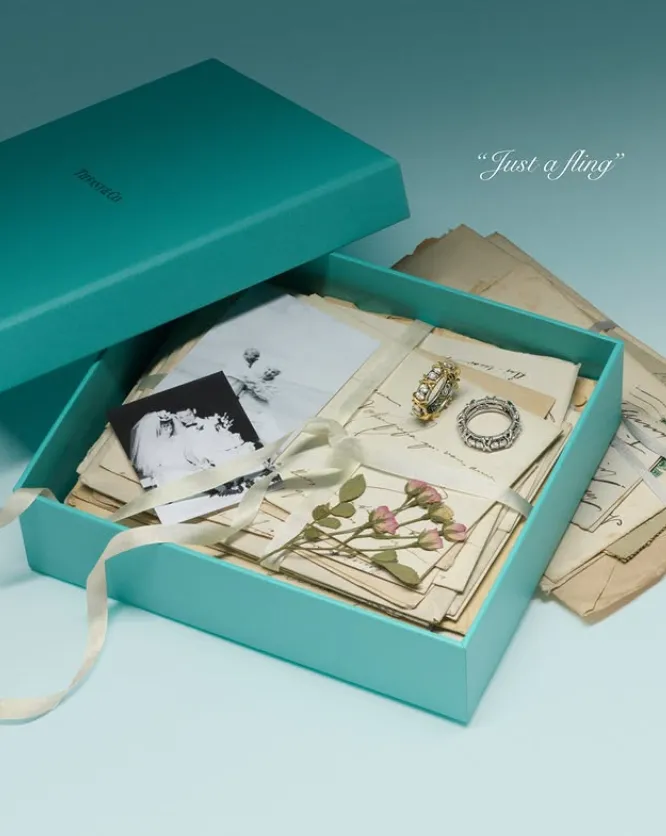 caja de color azul con cartas antiguas, fotos, flores y anillos