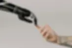 mano de hombre tocando mano de robot