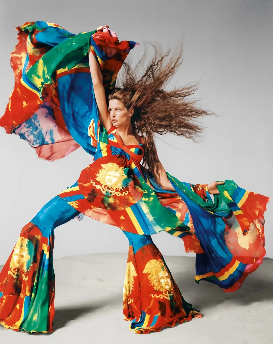 Chica con el pelo largo y traje multicolor posando