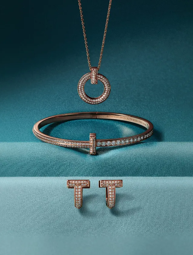 pendientes, pulsera y collar dorados sobre fondo azul