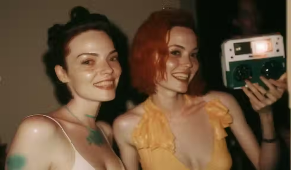 dos chicas haciéndose una foto con una cámara