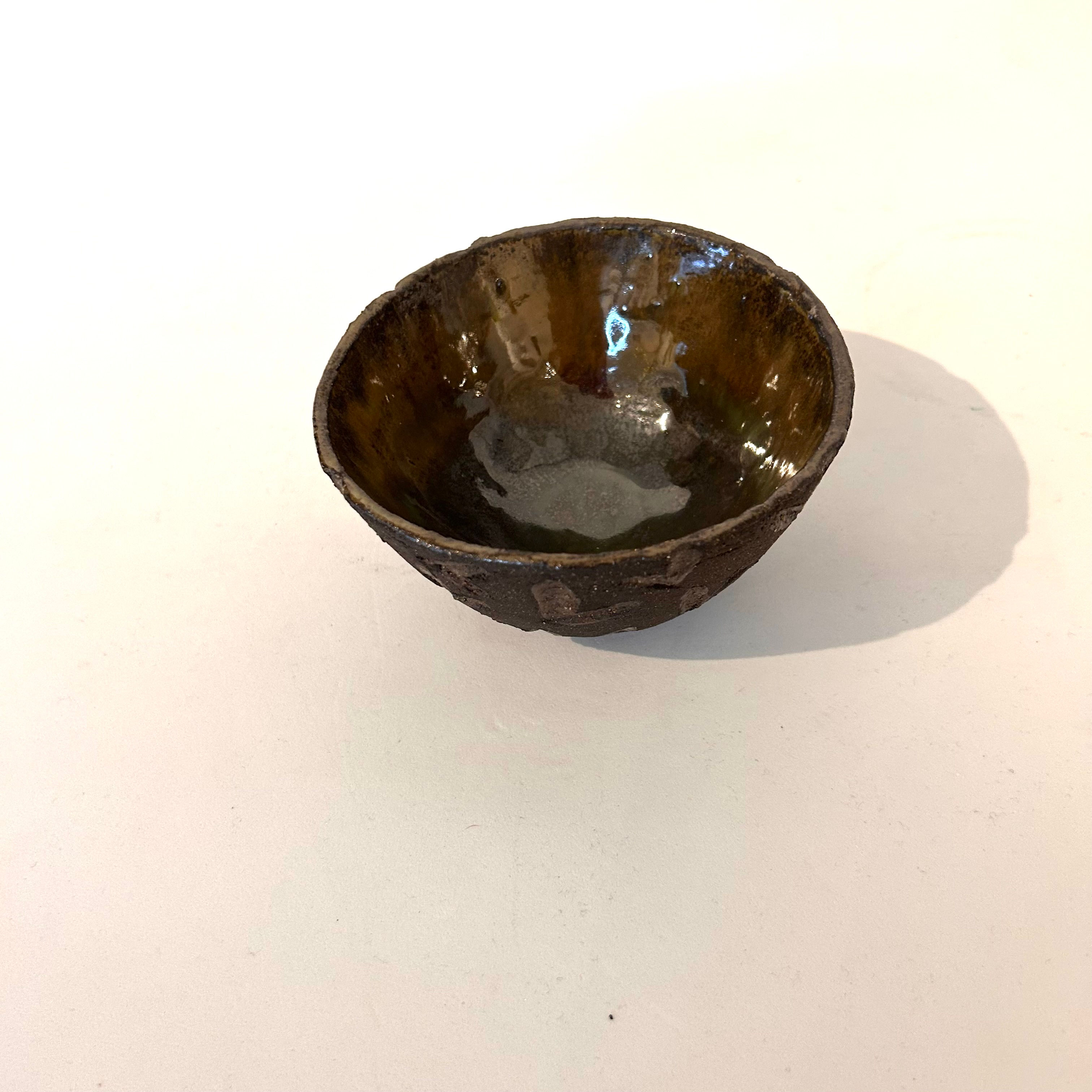 Liten brun skål med metallisk glasur inni