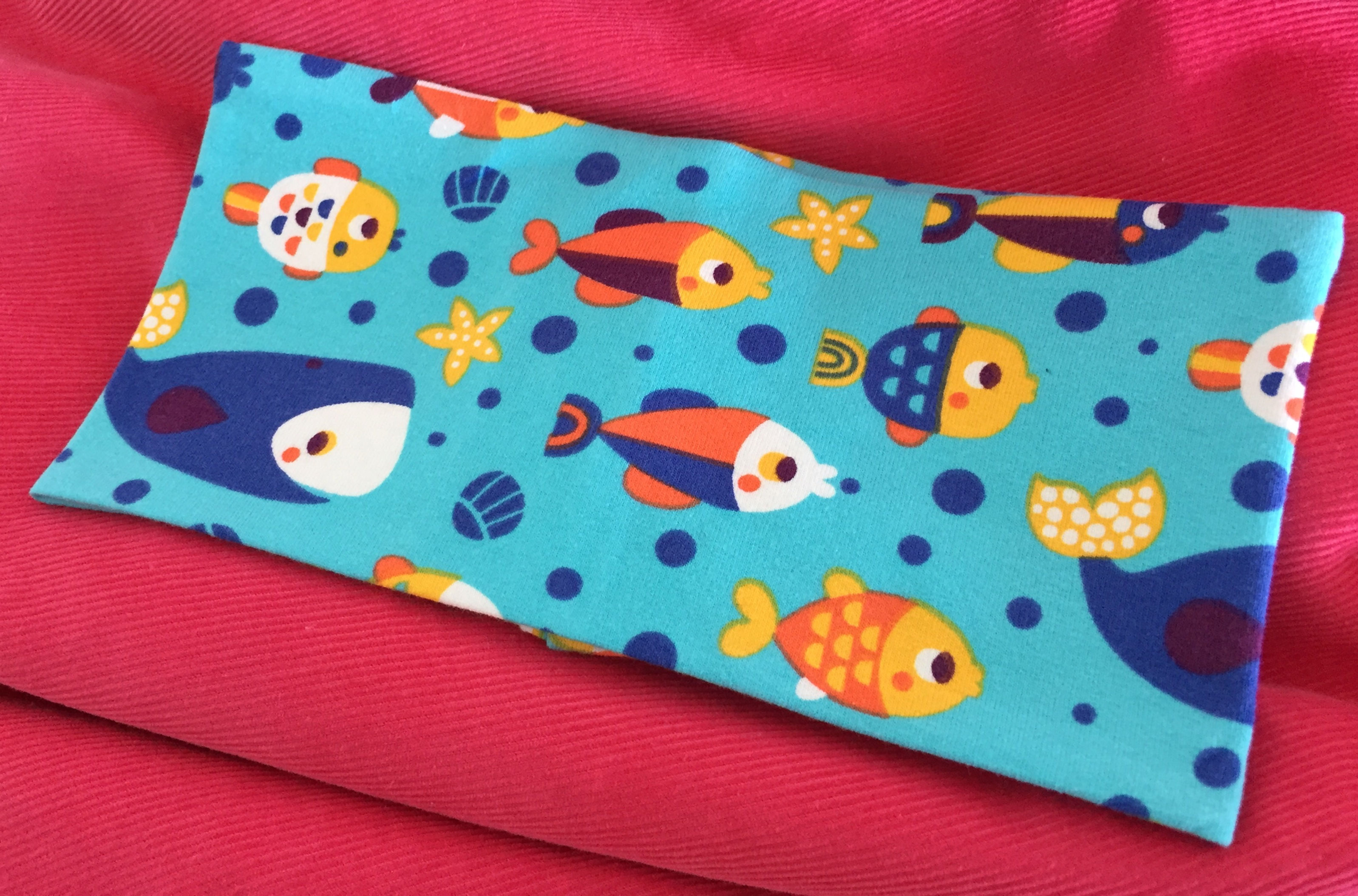 Blått pannebånd med fisk og hval. Unike, fargerike barneklær og luer håndlaget av Urk!