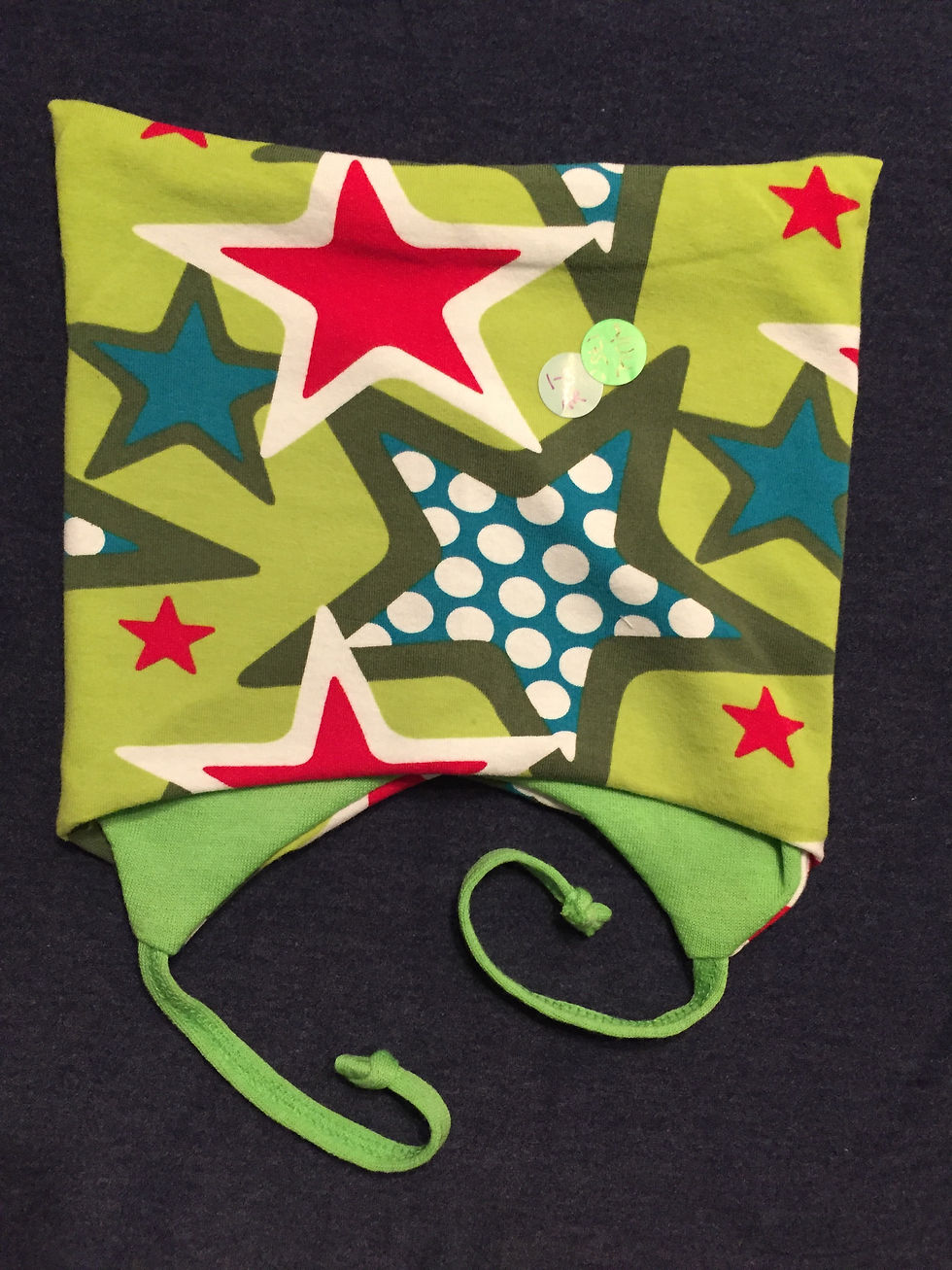 Lue sydd av grønn bomull med store stjerner. Foret med ull, og med knyting under haka. Håndlaget av Urk!