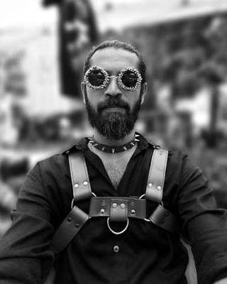 Shyam of Tassma in a leather harness and studded sunglasses