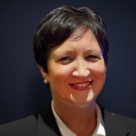 Smiling woman with short dark hair in professional attire.