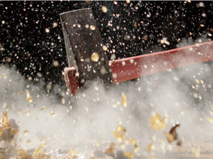 The explosion of debris and liquid from  a sledgehammer smashing a tea kettle full of tea 