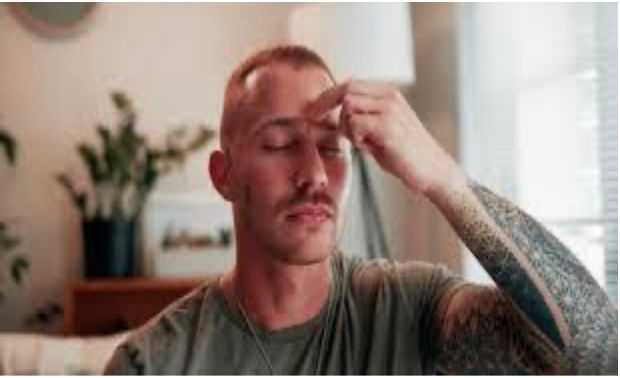 Image of man engaging in EFT practice tapping the space between his eyebrows