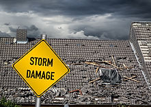 yellow damage warning sign in front of roof of house damaged by heavy hurricane tornado st