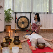 Sanghamitra using sound healing with gongs and bowls to cleanse and release dense energy from the aura at the AARAK School of Sacred Healing Arts in Rishikesh.
