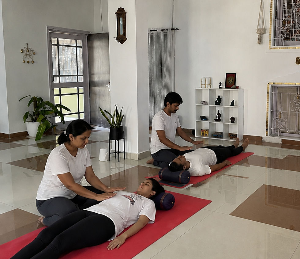 Two students practicing hands-on traditional Usui Reiki energy healing techniques during a small-group certification class at a specialized school in Rishikesh, India.