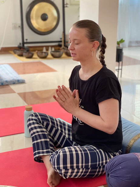 A student engaged in a quiet meditation practice with prayer hands during a Reiki course at AARAK School of Sacred Healing Arts in Rishikesh.