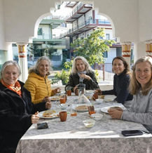 A group of students smiling and enjoying a shared meal together during a spiritual and healing retreat with Aarak School and Adhyakula in Rishikesh